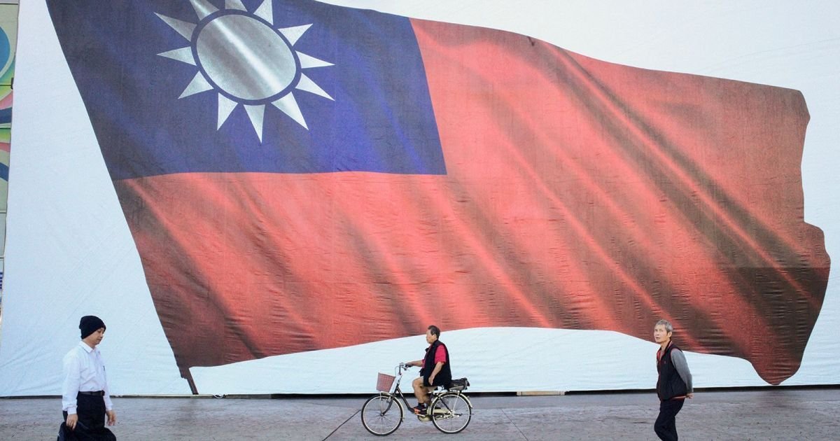 Pessoas passam por uma bandeira taiwanesa na cidade de Nova Taipé.  • Sam Yeh/AFP/Getty Image...